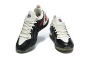 Pair of black and white Nike basketball sneakers with red accents shown from the front.