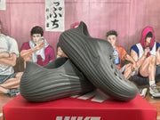 Angled view of a pair of smoke gray Nike sneakers displaying the low-top shape and sculpted side detailing.