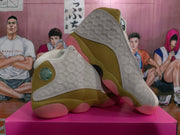 Angled view of the pair highlighting the embossed side panels, olive midsoles, and pink translucent outsole sections.