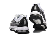 Rear and outsole views of the black and white Nike Air Max 97 sneakers.