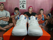 Front view of white Nike Zoom basketball shoes with blue and orange accents