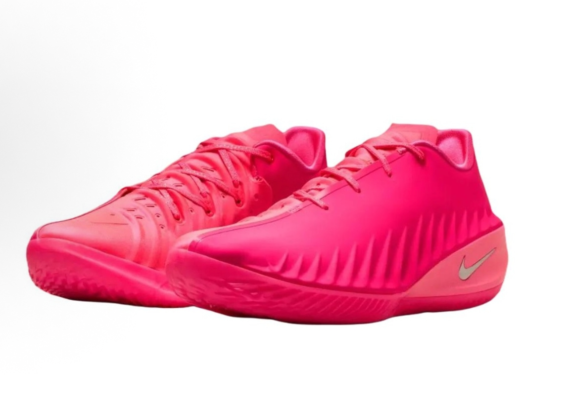 Pair of bright pink Nike basketball sneakers with lace-up fronts, textured side detailing, and metallic Swooshes.