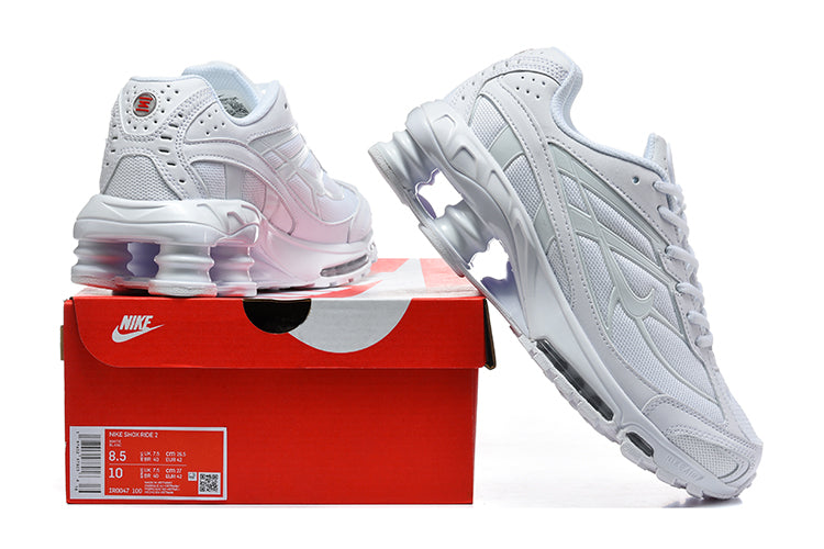 White Nike Shox Ride 2 sneakers displayed with a red shoe box; the box label shows a sample size.