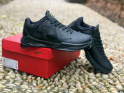 Black sneaker resting on a red Nike-branded box, with the shoe label area visible but not legible.