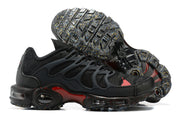 Side view of black Nike Air Max Terrascape Plus sneakers showing red accents, layered side panels, and patterned outsole.