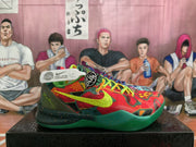 Side view of the red, green and yellow patterned sneaker with a green outsole and visible Nike branding.