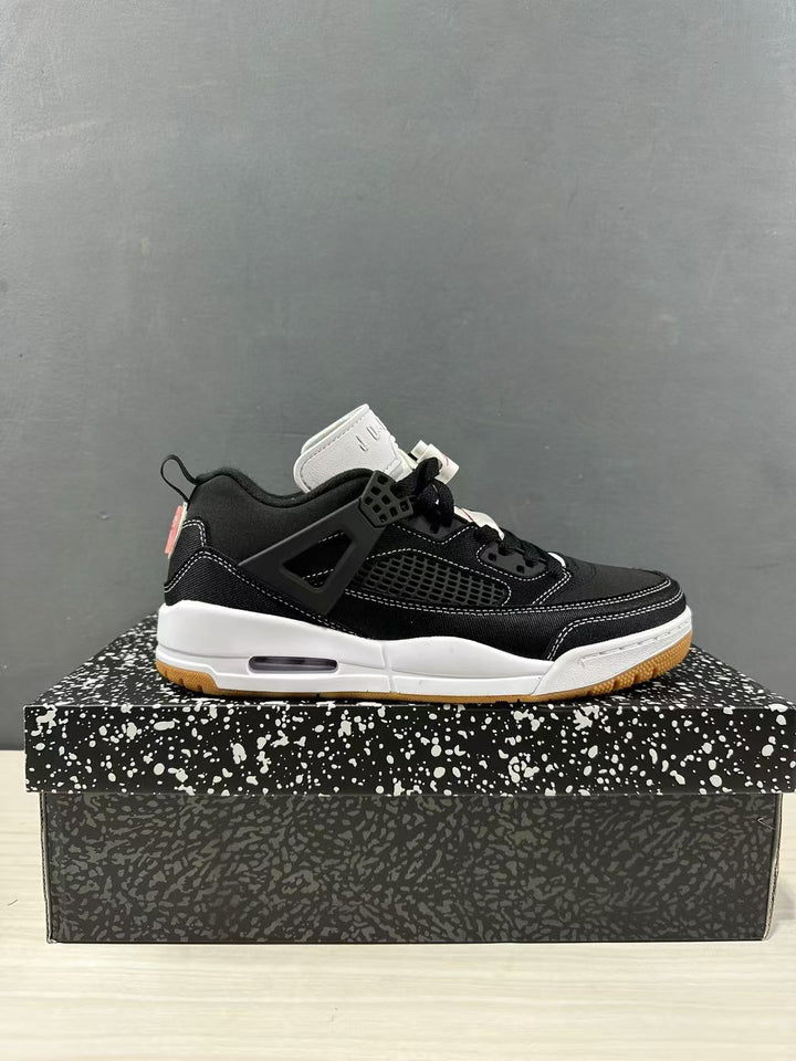 Side view of black and white Jordan Spizike Low sneakers displayed on a patterned shoe box.