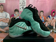 Angled view of two mint green and black Nike sneakers showing the side branding, laces, and sculpted upper.