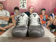 Front view of the pair showing white laces, patterned uppers, black tongue branding and grey outsoles.