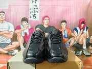 Front view of black lace-up sneakers with padded tongues.