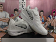 Angled view of white Nike sneakers displaying the black Swoosh and layered side construction.