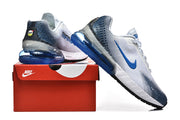 Side views of white and blue Nike Air Max sneakers displayed with a red Nike shoe box.