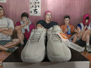Pair of gray Nike KD basketball sneakers shown from the front on a shoebox, with textured uppers, tonal laces, and black-and-orange hangtags.