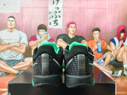 Rear view showing the black textured heel panels, silver accents, and green details