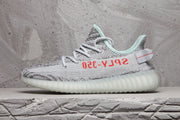 Side profile of the sneaker highlighting the gray patterned upper, red lettering, mint collar, and ribbed sole.