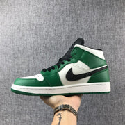 Side profile of a green, white, and black high-top sneaker held against a gray fabric background.