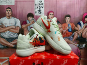 Angled view of the cream Nike sneakers displaying the red Swoosh, horse artwork, colored accents, and ribbed outsole.
