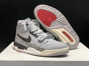 Angled view of the sneaker with one shoe lifted to show the patterned outsole and red traction areas.