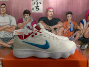 Side view of a white Nike sneaker showing the blue Swoosh, red collar trim, textured upper, and sculpted ribbed sole.