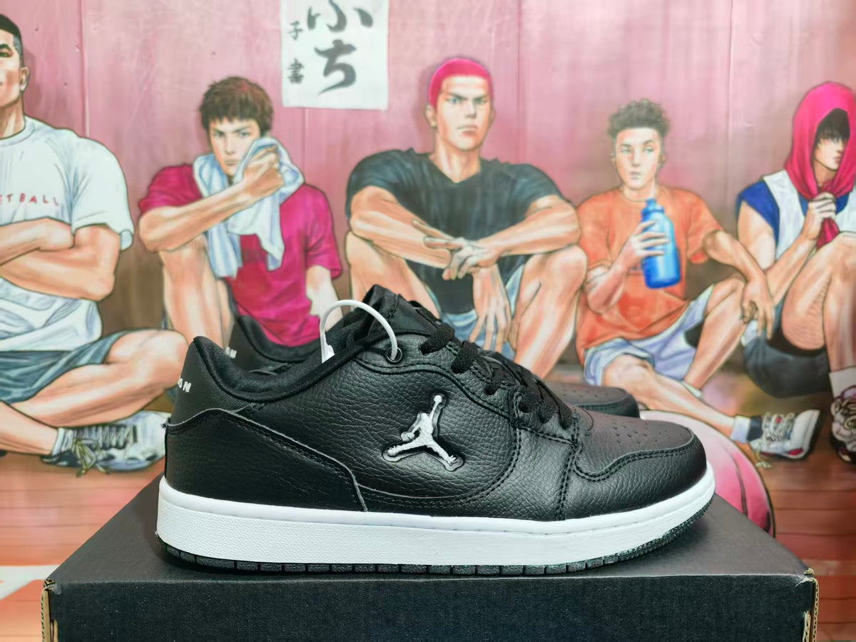 Side view of black low-top Jordan sneakers with a white midsole and black outsole.