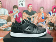 Side view of black low-top Jordan sneakers with a white midsole and black outsole.