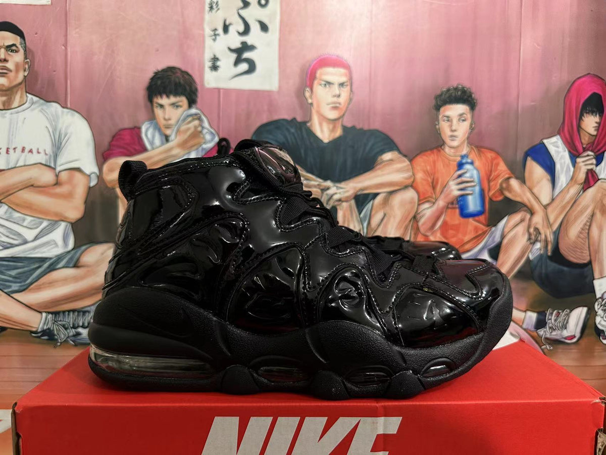 Black Nike high-top sneaker with glossy wavy side panels, shown in profile on a red box.