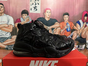 Black Nike high-top sneaker with glossy wavy side panels, shown in profile on a red box.