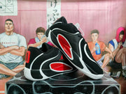 Angled side view showing black sneakers with red side panels, white trim, and Jordan branding.