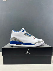 Side profile of a single white, blue, and grey Air Jordan 3 sneaker displayed on a shoebox.