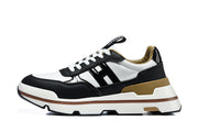 Side view of a black and white low-top sneaker with tan heel accents and a chunky striped sole.