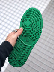 Handheld outsole view showing the green traction pattern and textured tread.