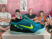 Side profile showing the blue patterned upper, bright volt Nike swoosh, black heel structure, and pale blue outsole.