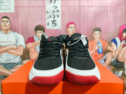 Front view of the pair showing black textured uppers, black laces, white midsoles, and red toe outsoles.