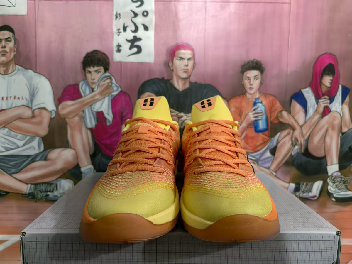 Front view of orange and yellow Nike basketball sneakers displayed on a box.