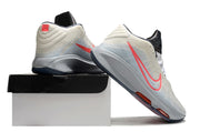 Light gray and coral Nike GT Hustle 3 shoes posed on and beside a shoe box.