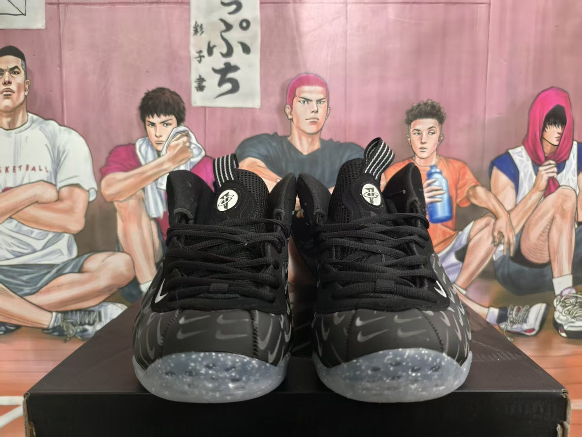 Front view of black high-top basketball sneakers with gray Swoosh-style graphics and translucent speckled soles.