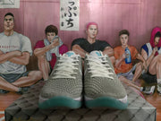 Front view of grey textured Nike basketball shoes with white laces and teal outsole accents