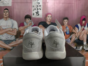 Rear view of the white and grey sneakers showing padded collars and Air branding embroidered on the heels.