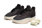 Pair of black low-top sneakers shown from above with layered panels, lace closures, and cream outsoles.