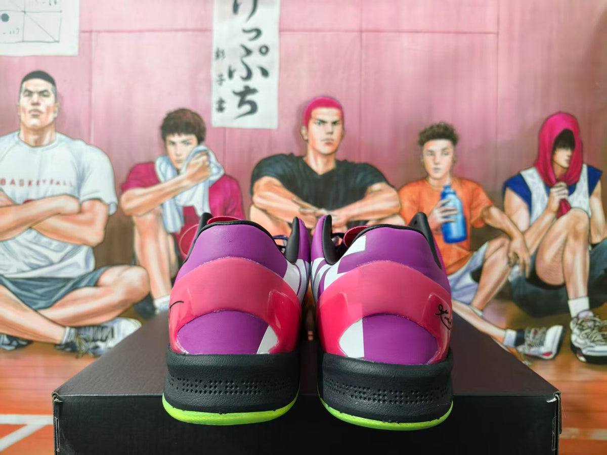 Rear view of pink and purple Nike sneakers with black midsoles and neon green outsole accents on a shoebox.