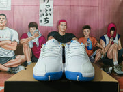 Front view of white and blue Jordan sneakers showing white laces, tongue logos, textured toe panels, and blue outsoles.