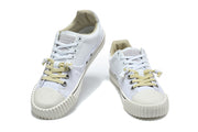 Pair of white low-top sneakers with cream-colored toe caps and mixed white and pale yellow laces.