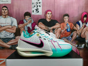 Side view showing the white Nike basketball sneaker, black Swoosh with pink edging, perforated panels, and turquoise toe outsole.