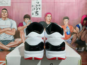 Rear view of the pair showing white heels, glossy black heel panels, red logo accents, and red outsole sections.