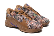 Angled view of the pair showing camouflage toe panels, brown laces, and purple accents.