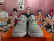 Front view of gray Nike sneakers with gray laces, textured uppers, and white ribbed soles.
