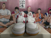 Front view of white and grey sneakers with red accents, mesh panels, and gum-colored outsoles