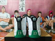 Rear view of white and green Jordan high-top sneakers with black heel tabs and green number 23 details