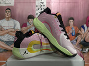 Pair of black and pink Jordan basketball shoes shown at an angle, with lime-green midsoles and orange accents.