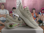Angled view showing the beige upper, sculpted sole, and colorful floral-patterned side panel.